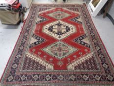 A machine made Persian carpet on red ground,