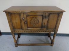 A carved oak cabinet on raised legs