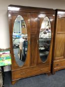 An Edwardian inlaid mahogany double mirror door wardrobe fitted with a drawer