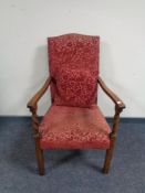 An Edwardian oak armchair in brocade fabric