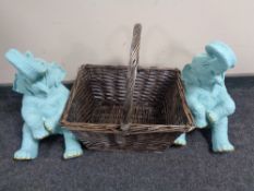 A wicker hand basket together with two elephant figures.