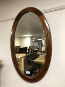 An Edwardian mahogany oval framed mirror