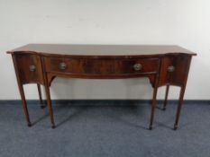 A mahogany Edwardian serpentine fronted sideboard on raised legs, 183 x 62 x 92 cm.