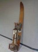 A vintage Gilcraft water ski together with a canvas golf bag containing seven assorted driver's and