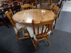 A circular pine pedestal kitchen table together with four chairs