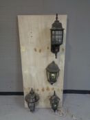 Four exterior coach lights mounted on a board