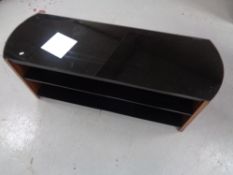 A contemporary three tier black glass audio stand