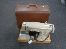 A cased Singer electric sewing machine