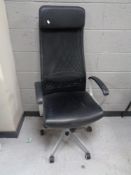 A contemporary high backed office armchair in black leather and mesh fabric