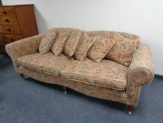 A Victorian style low backed settee in tapestry fabric with six cushions
