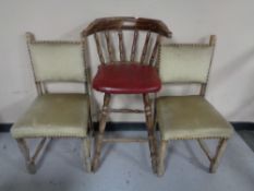 A bar chair together with a pair of blond oak dining chairs
