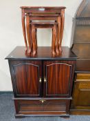 A television cabinet in mahogany finish together with a nest of three tables