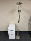 An Ikea white five drawer chest together with a floor lamp