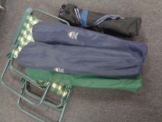 Two folding garden armchairs together with three further chairs and a folding table in carry bags.