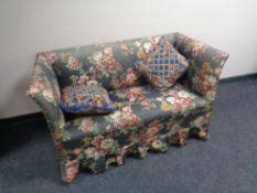 An early 20th century settee upholstered in a floral fabric together with two scatter cushions