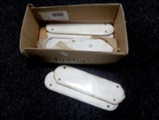 A box containing early 20th century ceramic finger plates.