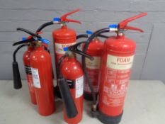 Seven various fire extinguishers.