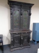 A 19th century profusely carved continental oak hunting cabinet with leaded glass doors and