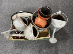 A box containing three galvanized watering cans together with a quantity of plastic plant pots.