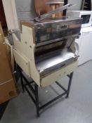 A Delta commercial bread slicer on stand.