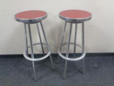 Four circular aluminium bar stools.
