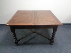 An Edwardian oak extending dining table on barley twist legs