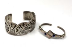 A sterling silver bangle and a silver and opal bangle.