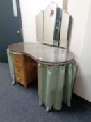 A mid century kidney shaped dressing table with triple mirror