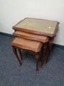 A nest of three leather topped tables