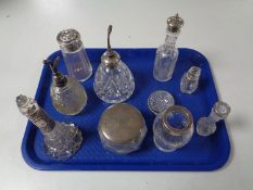 A tray containing a quantity of silver lidded and rimmed dressing table bottles,