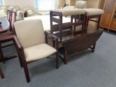 A 20th century stained beech framed armchair together with two foot stools upholstered in a beige