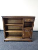 A set of oak open bookshelves, fitted cupboard and drawer.