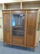 A continental inlaid oak triple door cabinet with brass mounts.