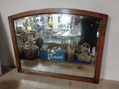 An Edwardian oak framed bevel edged mirror.