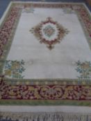 A fringed woolen carpet on cream ground with central medallion and borders.