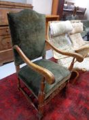 An early 20th century carved oak scroll arm armchair.