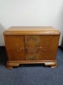 A carved oak double door low cupboard.