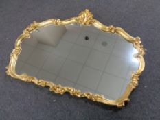 A shaped gilt framed overmantel mirror.