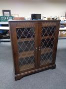 A double leaded glass door bookcase in an oak finish.