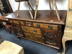 An Art Nouveau mahogany and walnut sideboard with brass drop handles.