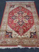 A machined Heriz design rug on red ground