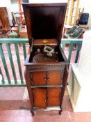 An early 20th century oak cased Gilbert gramophone in cabinet with a small quantity of 78's