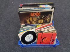 A crate containing vinyl LPs and 45 singles including ACDC, The Pogues, The Clash, The Jam,