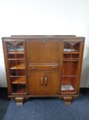 A 1930s carved oak bureau display cabinet