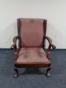 An Edwardian wing back armchair on pad feet