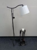 A contemporary metal floor lamp on tripod support together with a wrought iron companion set/