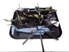 A tray containing six die cast model helicopters on stands.