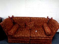 A contemporary drop end settee upholstered in a red floral fabric