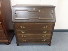 A 20th century writing bureau fitted four drawers with brass mount and handles in an oak finish