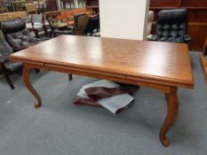 A contemporary extending dining table on cabriole legs in a walnut finish
